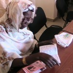 A Senegalese woman examines health insurance information.
