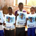 Students hold their new bed nets at Tanga Primary School.