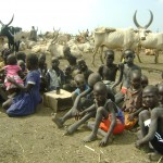 Children in a cattle camp in South Sudan learn their mother tongue with a digital audio player