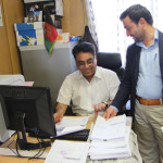 A telecommunications company employee checks with a customs official on release of his imports.