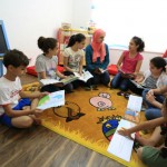 Children discuss stories they read in their weekly book club meeting with Eman Awamleh, founder of Carnaval Play & Learn.