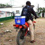 A health professional transports lab samples on a motorcycle procured with USAID support 