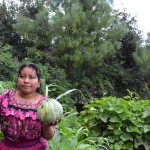 Sheny holds a vegetable from her home garden