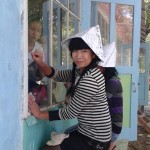 Adina, with other volunteers, repairs and reconstructs summer camp cottages at a  residential institution for young orphans.