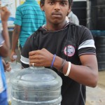 A slum dweller in Bangalore’s Lingarajpuram district holds a can of purified water.