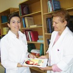Sadeta Noka (left) receives the new pediatric Clinical Practice Guidelines from Margarita Rumano