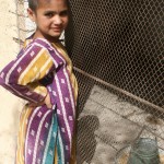 A girl in Mastung District stands by her family’s new chicken coop, where the chickens stay to beat the midday heat.