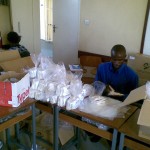 Staff re-packaging the female condoms in packs of 20 pieces.