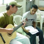 Manfer Manuel Guzm&aacute;n gives a student free music lessons while volunteering at the USAID-supported Ciudad del Sol Youth Ou