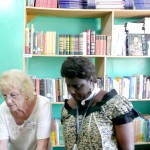 Peace Corps Response Volunteer Gloria Reichmann (left) organizes books and supplies with a local staff member at a USAID Learnin
