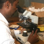 A lab technician examines samples for suspected TB in Karachi.