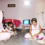 Tania Khatun and her children enjoy watching the solar-powered television. 
