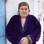 Shulabibi Ismatova stands in her yard following her recovery. The burns on her neck and chest are visible.