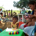 Families meet at a rural children's center to monitor their children's development and receive complementary food.