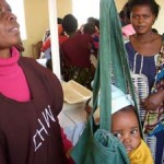 During Child Health Week in Zambia, community health volunteer Mary Kafumbe weighs Joshua Matabula