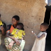 Community health worker Rosalina Casimiro, far left, meets with a family in Nampula province, Mozambique, to distribute kits for