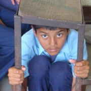A student from Shree Janaudaya Lower Secondary School in Kathmandu, Nepal, demonstrates how to take cover during an earthquake. 