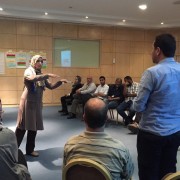 A participant in the USAID Libya Gender & Elections BRIDGE workshop engages men and women in discussion.