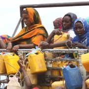 Ethiopian women grab containers with filled with fresh water