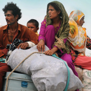 Pakistanis return home with their belongings to Bassera village in Punjab province in August 2010 as flood waters recede.