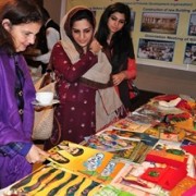 U.S. Consul General Nina Fite browsing through various education material on Alif Laila Book Bus Society stall at the USAID Educ