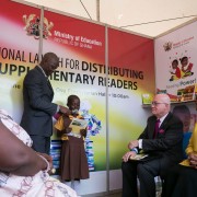 Amb. Robert Jackson listens to a child read one of the books distributed