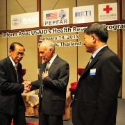 Michael Yates, center, director of the USAID Regional Development Mission for Asia, congratulates Praphan Phanuphak, director of