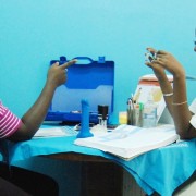A family planning counselor displays oral contraceptives to a university student
