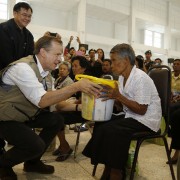 U.S. Ambassador to Thailand Glyn T. Davies helps hand out supplies in Nakhon Si Thammarat, Thailand to residents affected by recent flooding.
