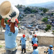 A woman catches a bucket in a line for rubble removal in the hilly Ravine Pintade neighborhood in Port-au-Prince, Haiti, on Feb.