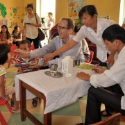 USAID Mission Director Joakim Parker gives a dose of deworming medicine to kindergarten children in Nam Dinh Province.