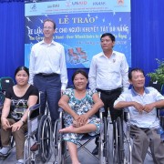 USAID Mission Director Joakim Parker, second from left, helps hand over wheelchairs to people with disabilities in Danang.