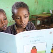 Two girls in a second grade class at the Soyama Primary School practice reading with one of the new supplementary books.