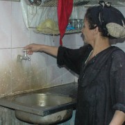 Woman turns on water faucet in her home