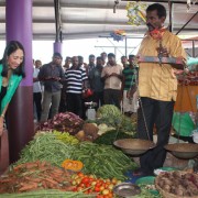Ambassador Sison and USAID Mission Director Carlin speak to a vegetable vendor during the public market opening in Mullaitivu