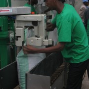 A worker at the new fertilizer blending facility operates the machine to seal the bags of finished product after the raw compone