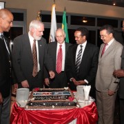 Thomas Staal, Donald Booth, and Ethiopian officials stand around USAID cake