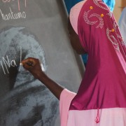 A young woman in Niger practices writing in her literacy class.