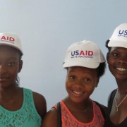 Three youth in USAID hats