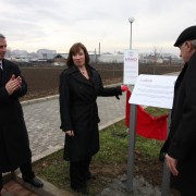 Ambassador Jacobson unveils a plaque commemorating DEMI’s park and sidewalk project