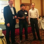 USAID's Steve Rynecki (left) presents the "Social Impact of the Year Award" to Rob Nazal of BPI Globe BanKO (center) in a ceremo