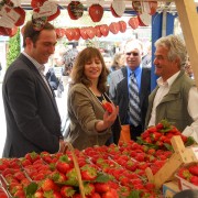 USAID Director and Minister of Agriculture tour the strawberry booths and talk to farmers 