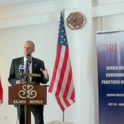 US Ambassador to Kenya speaks behind a podium flanked by Kenyan and American flags