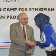 U.S. Ambassador Donald Booth presents a completion certificate to one of the 167 first-year female students.