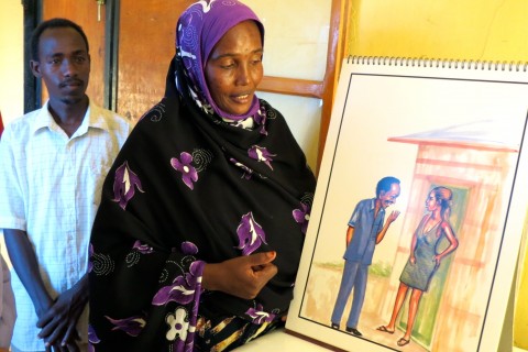 Zahra Daher displays a picture used in HIV/AIDS training. 