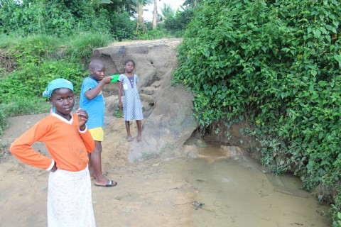 Three Kids are drinking water from a dirty pound