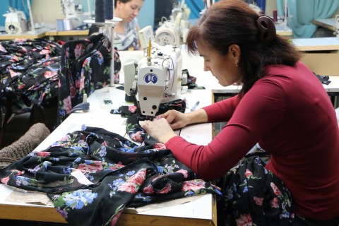 Female worker sews garment at Portavita clothing factory